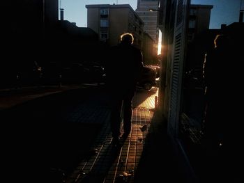 Silhouette man standing in city at night