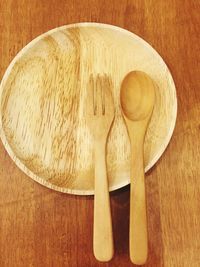 High angle view of wooden cutlery and plate on table