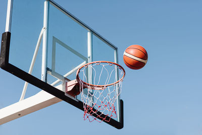 Low angle view of basketball hoop against blue sky