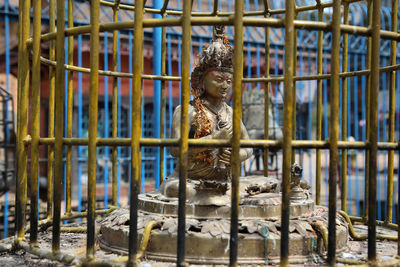 Statue in cage at buddhist temple