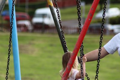 Rear view of girl on swing at playground