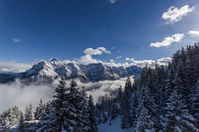 Scenic view of snowcapped mountains against cloudy sky