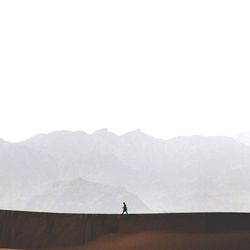 Man standing on mountain against clear sky