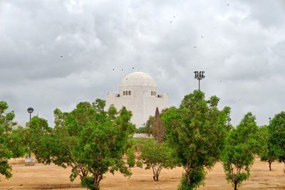 Trees and plants against cloudy sky