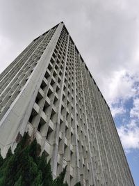 Low angle view of modern building against cloudy sky