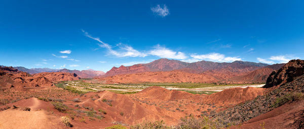 Scenic view of mountain range against blue sky