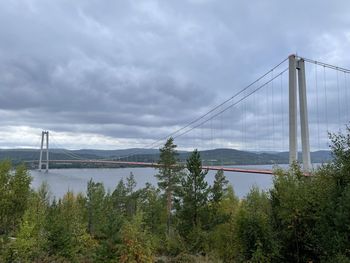 View of suspension bridge against cloudy sky