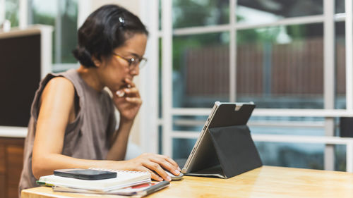 Young woman using laptop at table