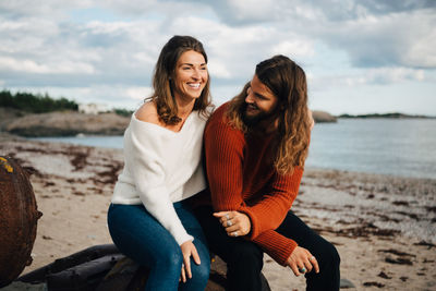 Smiling couple spending leisure time at beach