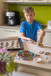 Portrait of boy playing with cookies on table