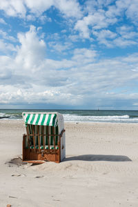 Lounge chairs on beach against sky