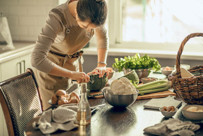 Young woman peels the green pumpkin. cooking a vegan lunch