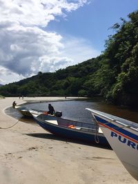 Boats moored on beach against sky