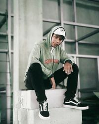 Portrait of young man sitting on skateboard