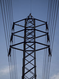 Low angle view of electricity pylon against sky