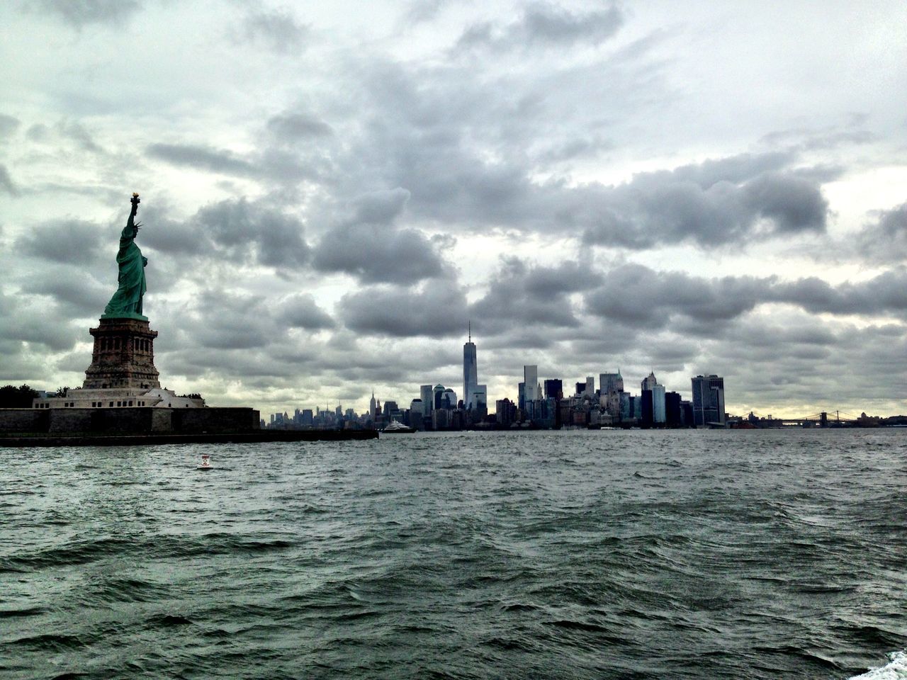 waterfront, architecture, building exterior, built structure, water, sky, city, cloud - sky, tower, travel destinations, sea, famous place, tall - high, international landmark, rippled, cityscape, capital cities, travel, cloudy, river