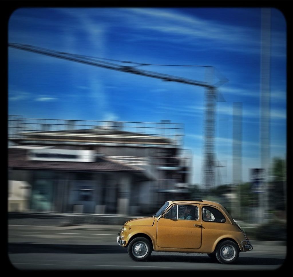 transfer print, transportation, mode of transport, car, land vehicle, auto post production filter, sky, glass - material, transparent, window, road, on the move, travel, vehicle interior, cloud - sky, building exterior, built structure, cloud, city, street