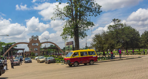 Cars on street in city against sky