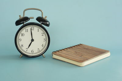 Close-up of alarm clock against blue background