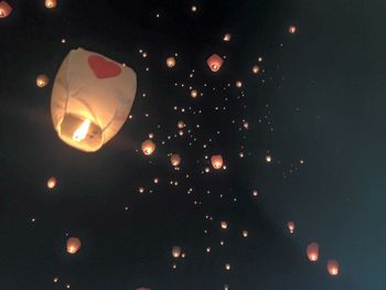 Low angle view of illuminated lights against sky at night