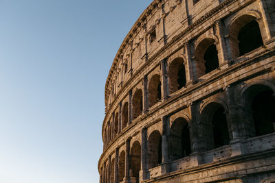 Low angle view of coliseum against clear sky