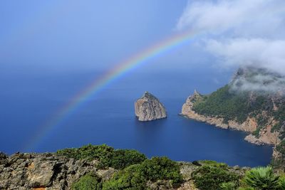 Scenic view of rainbow over sea against sky