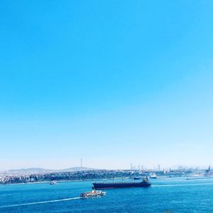 Sailboats in sea against clear blue sky