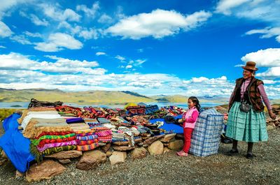 People standing on mountain against sky
