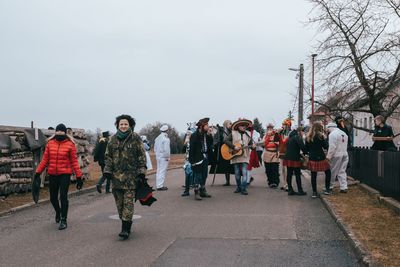 People walking on street in city against sky