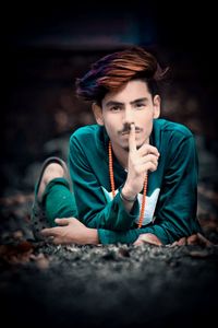 Portrait of young man sitting on land