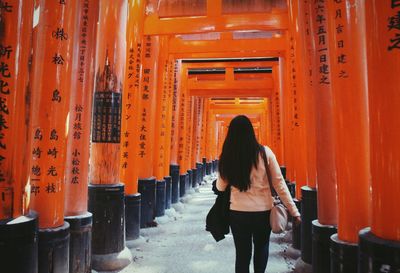 Rear view of woman walking in temple building