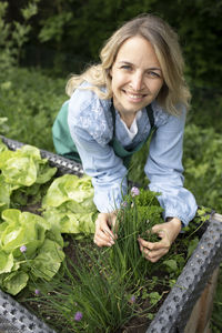 Portrait of a smiling young woman holding plants