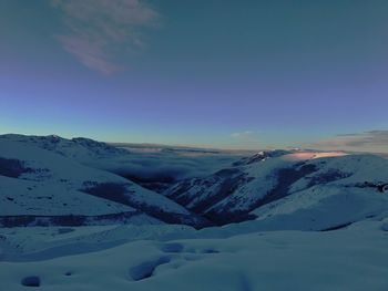 Scenic view of snowcapped mountains against sky during sunset