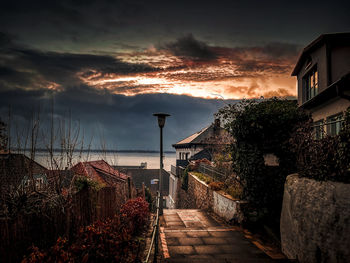 Street amidst buildings against sky at dusk