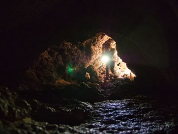 Boy with flashlight in cave