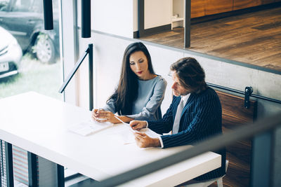 Businessman discussing with colleague at desk in office