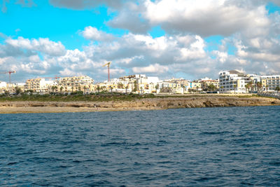 View of sea and buildings against sky