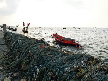 Fishing boats in sea against sky