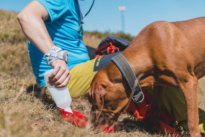 Midsection of man with dog on field