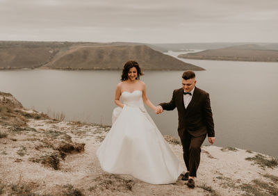 Rear view of bride standing on beach