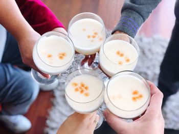 High angle view of people holding toasting drinks