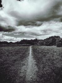 Scenic view of field against cloudy sky