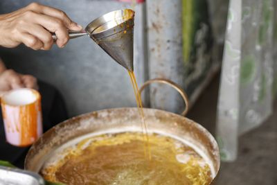 Close-up of person preparing pouring coffee in kitchen