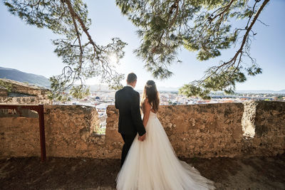 Rear view of couple holding hands