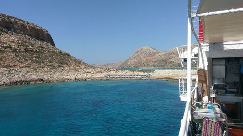 Sailboat in sea against clear blue sky
