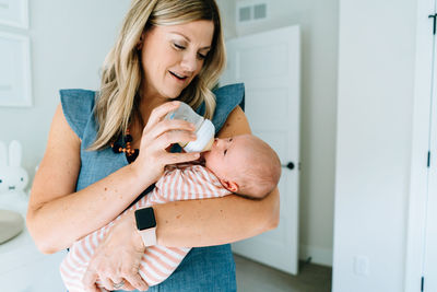 Closeup portrait of a mother bottle feeding her newborn baby girl