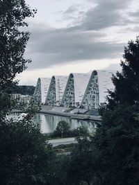 Bridge over river in city against sky