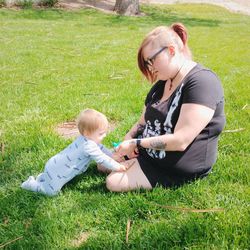 Rear view of mother and daughter on field