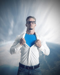 Portrait of young man standing against sky