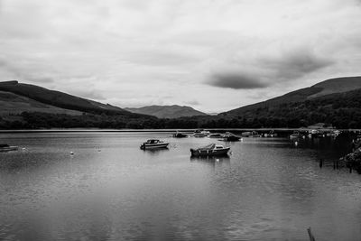 Sailboats moored on lake against sky